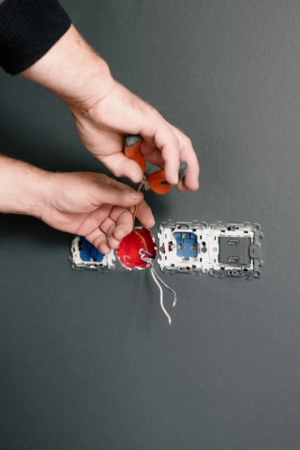 Electrician working on wiring for wall sockets